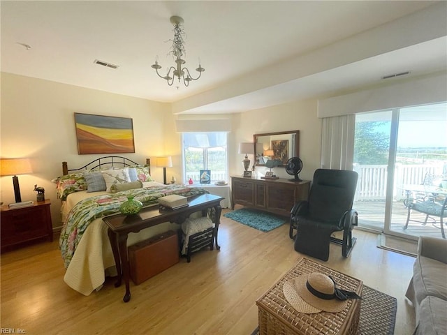 bedroom featuring light wood-type flooring, a chandelier, and access to outside