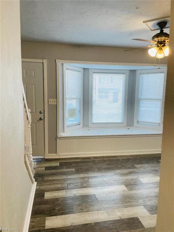 interior space with dark wood-type flooring, a textured ceiling, and ceiling fan