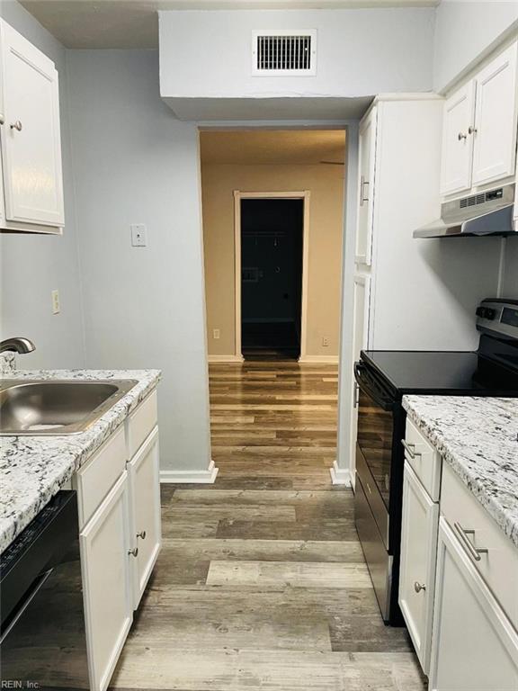 kitchen featuring black appliances, sink, light hardwood / wood-style flooring, and white cabinets