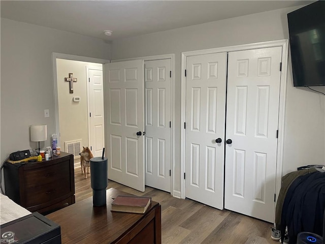 bedroom featuring two closets and hardwood / wood-style flooring