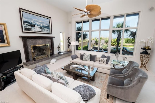 living room featuring ceiling fan and a high end fireplace