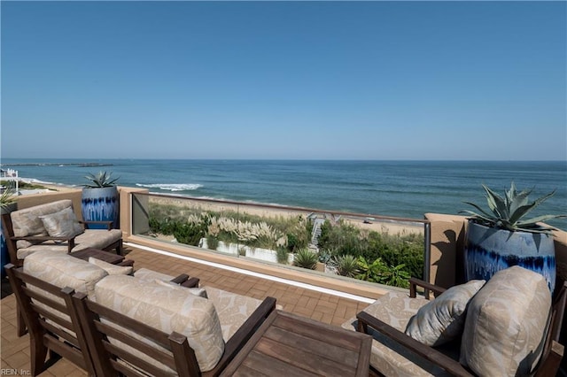 exterior space with an outdoor living space, a beach view, and a water view