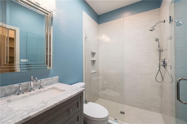 bathroom featuring walk in shower, toilet, and vanity