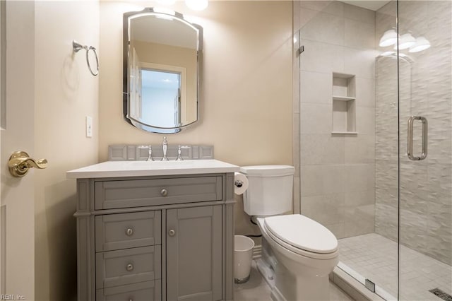 bathroom featuring vanity, toilet, and an enclosed shower