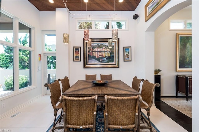 dining area with wood ceiling, plenty of natural light, hardwood / wood-style flooring, and a high ceiling