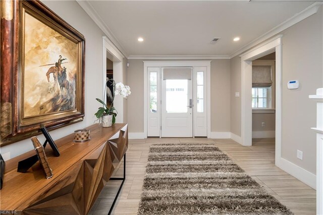 foyer entrance with ornamental molding and light wood-type flooring