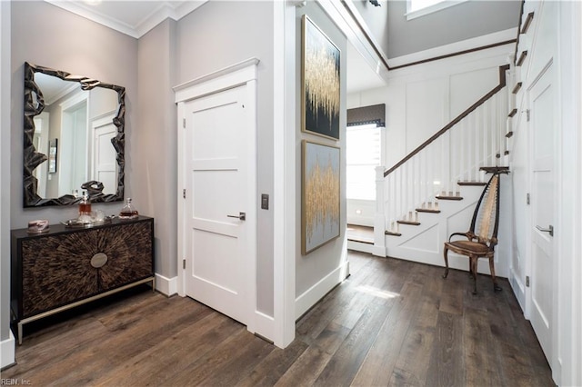 entrance foyer with dark hardwood / wood-style floors and crown molding