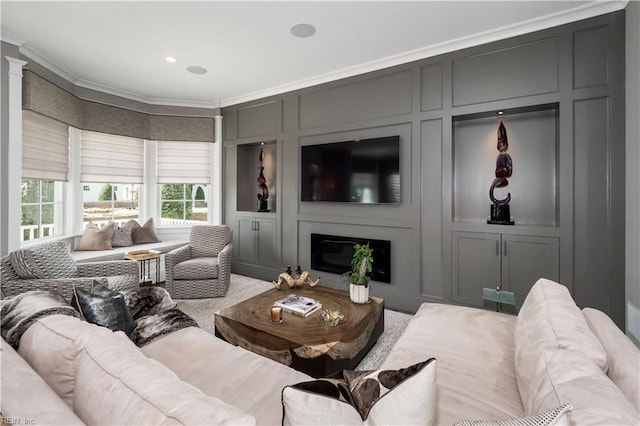 carpeted living room with crown molding and a large fireplace