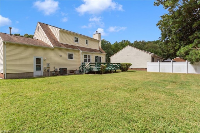 rear view of property featuring central AC unit, a lawn, and a wooden deck