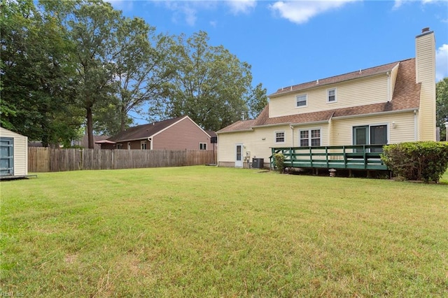 back of house with central air condition unit, a lawn, and a wooden deck