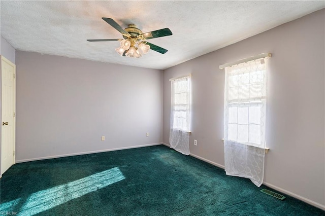 carpeted empty room featuring ceiling fan and a textured ceiling