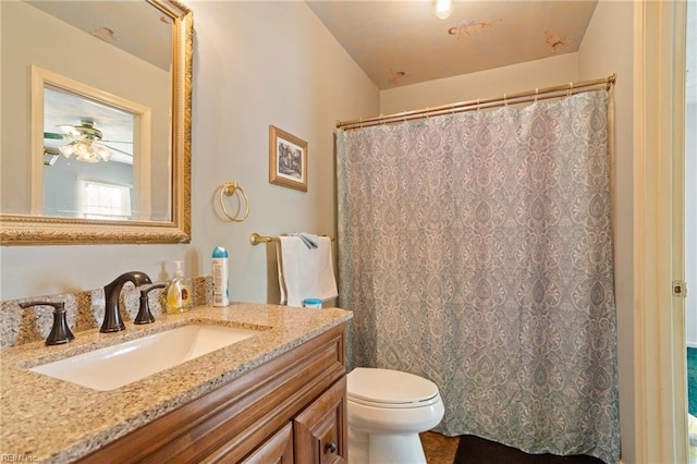 bathroom featuring curtained shower, vanity, ceiling fan, and toilet