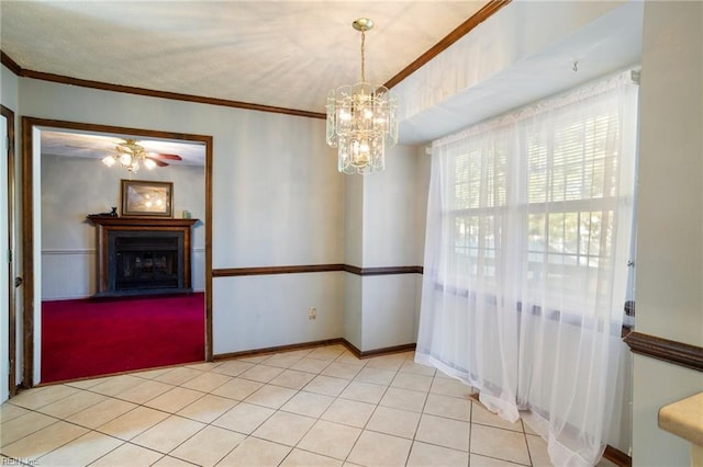 unfurnished dining area featuring ceiling fan with notable chandelier and crown molding