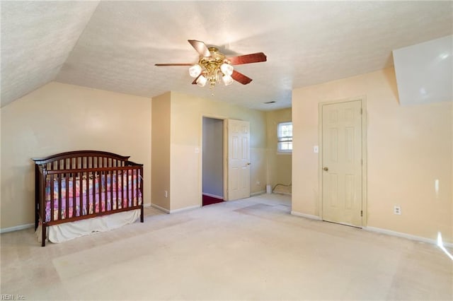 unfurnished bedroom with vaulted ceiling, light colored carpet, ceiling fan, and a textured ceiling