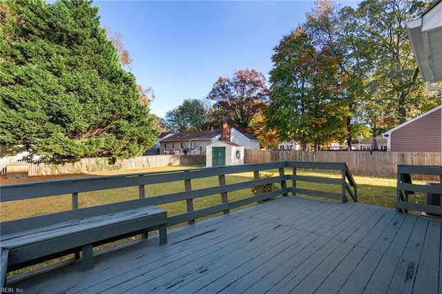 wooden terrace featuring a yard and a storage unit