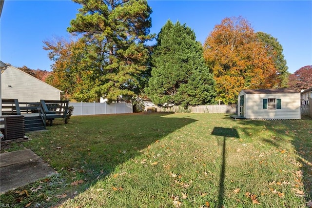 view of yard with a storage unit, central AC unit, and a wooden deck