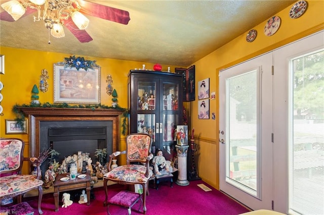 living area featuring ceiling fan and carpet flooring