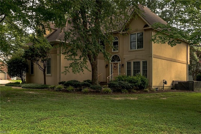 view of front of property featuring stucco siding and a front yard