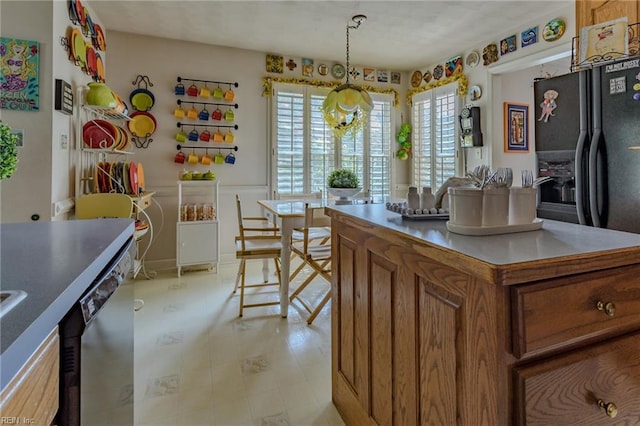 kitchen with brown cabinets, a center island, black refrigerator with ice dispenser, and stainless steel dishwasher