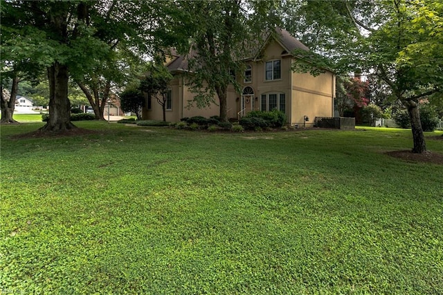 exterior space with stucco siding and a front lawn