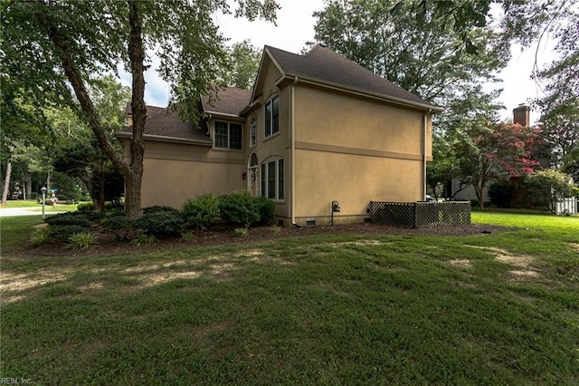 view of side of property with stucco siding and a lawn