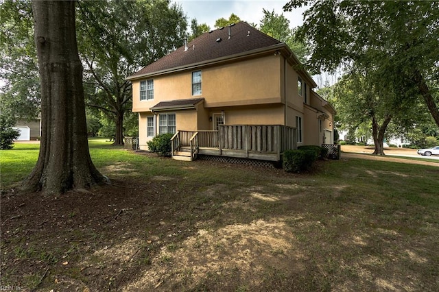 back of property featuring a wooden deck and stucco siding