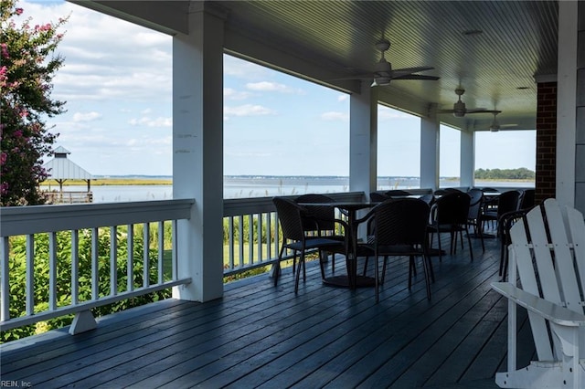 wooden deck with a ceiling fan and a water view