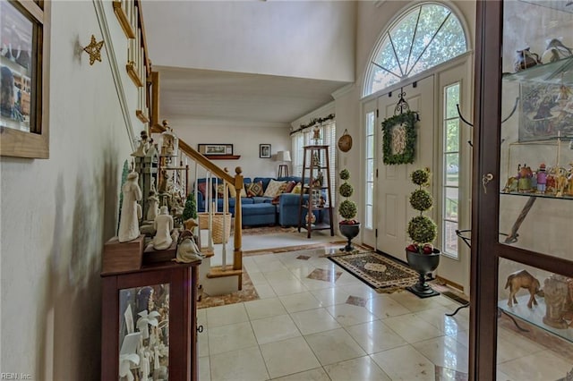 entryway featuring light tile patterned flooring, stairs, and ornamental molding