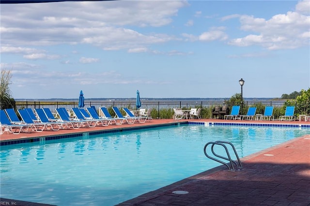 pool with a patio and fence