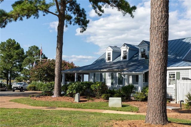 view of front of house featuring metal roof, a front lawn, and a standing seam roof