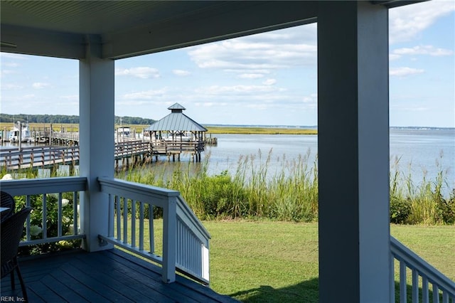 wooden deck with a yard and a water view