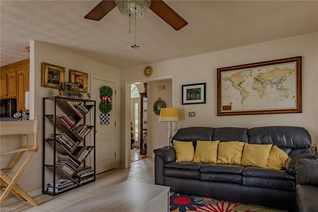 living area with light tile patterned flooring and ceiling fan