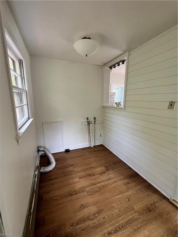 washroom with dark hardwood / wood-style floors and wooden walls