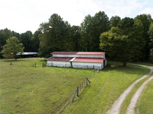 exterior space featuring a yard, a rural view, and an outdoor structure