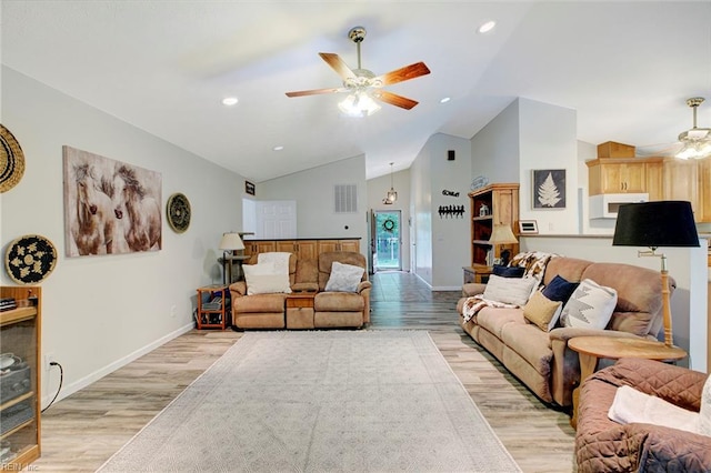 living room featuring lofted ceiling, ceiling fan, and light wood-type flooring