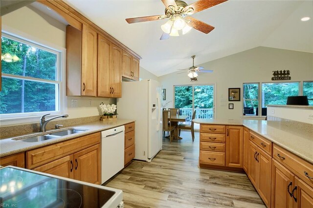 kitchen featuring light wood-type flooring, ceiling fan, white appliances, and kitchen peninsula