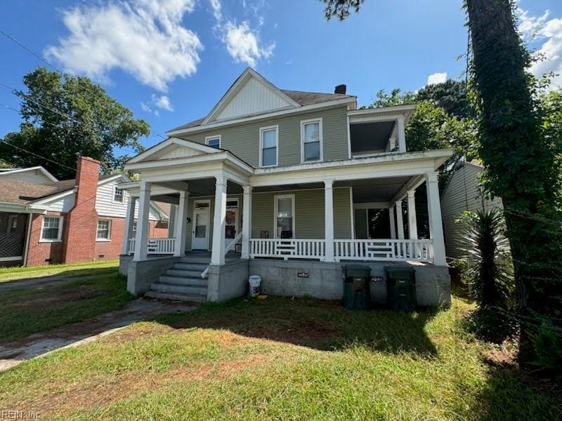 view of front of house featuring covered porch and a front lawn