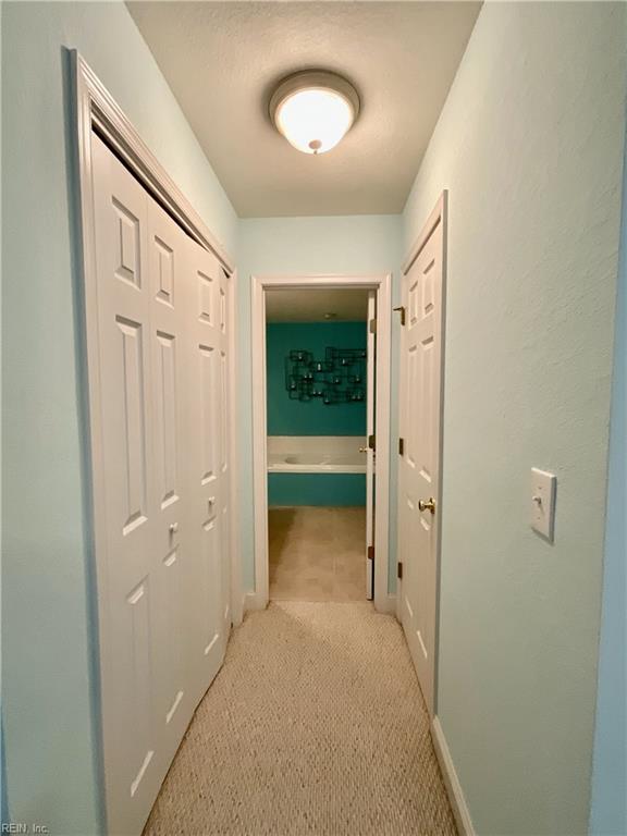 hallway featuring light carpet