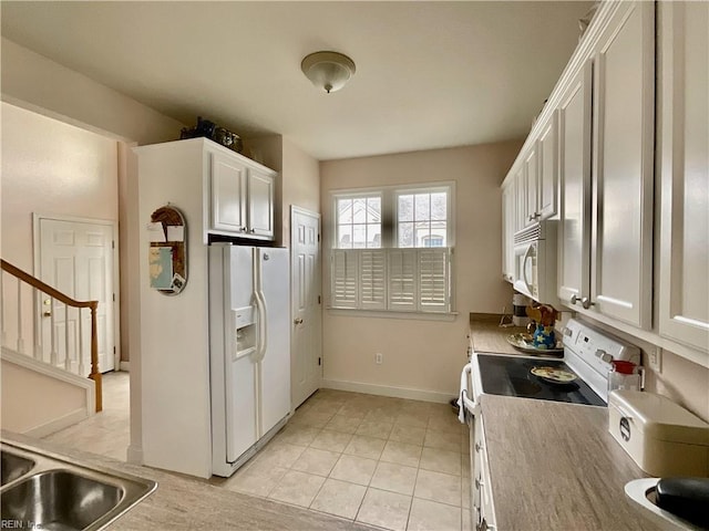 kitchen featuring sink, light tile patterned floors, white appliances, and white cabinets