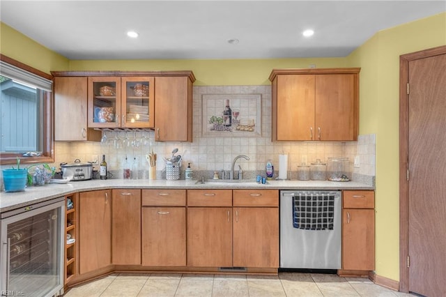 kitchen featuring beverage cooler, stainless steel dishwasher, sink, and decorative backsplash