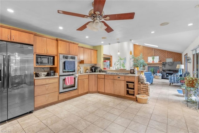 kitchen with appliances with stainless steel finishes, sink, lofted ceiling, light tile patterned flooring, and ceiling fan