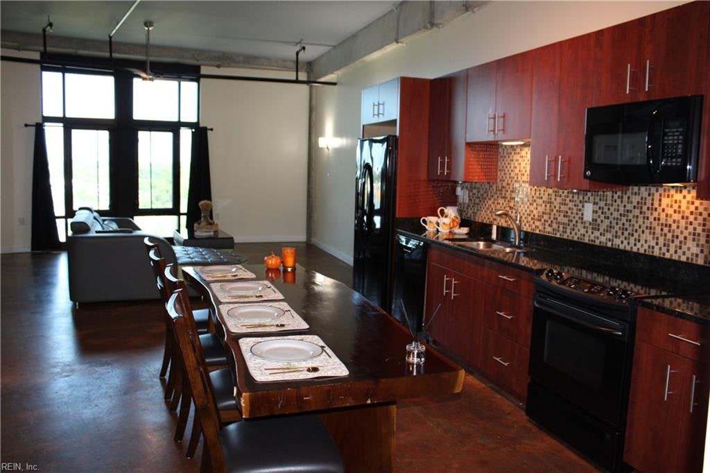 kitchen featuring sink, black appliances, and backsplash