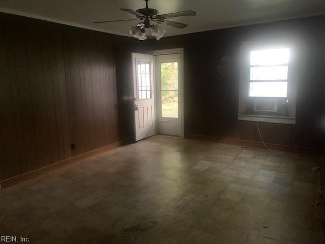 empty room with wood walls and ceiling fan