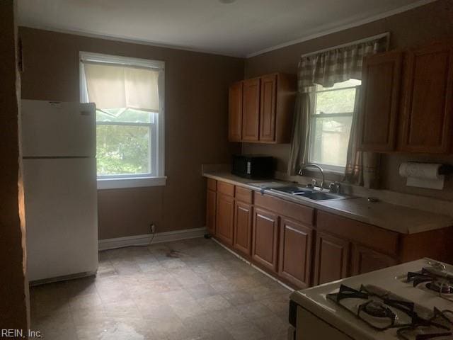 kitchen with white appliances, ornamental molding, and sink