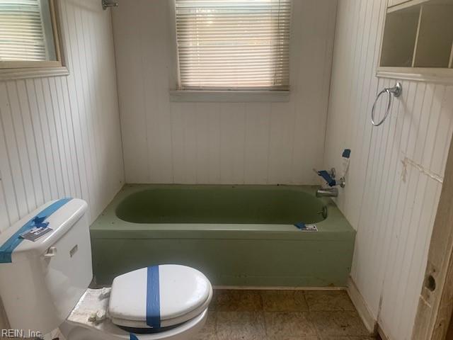 bathroom with toilet and a bathing tub