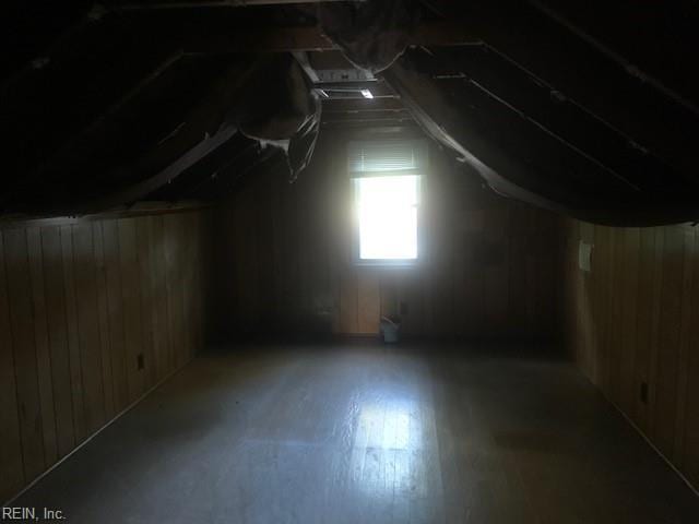 additional living space featuring lofted ceiling, wood-type flooring, and wood walls