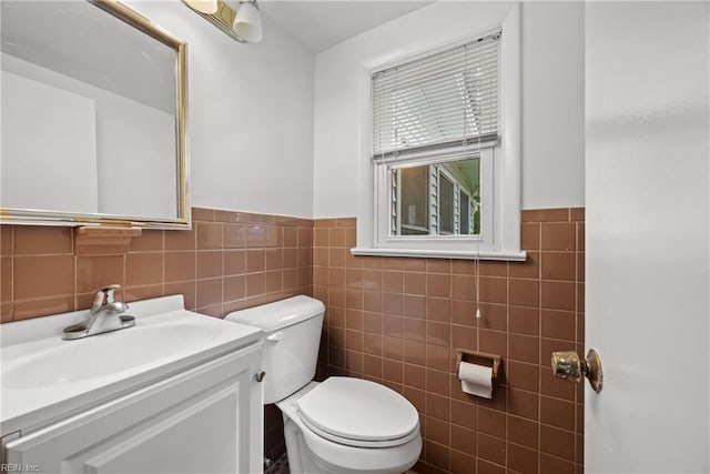 bathroom featuring backsplash, vanity, toilet, and tile walls