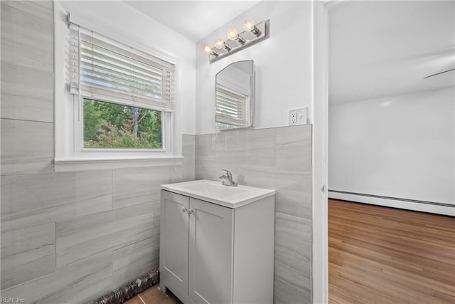 bathroom with tile walls, wood-type flooring, and vanity