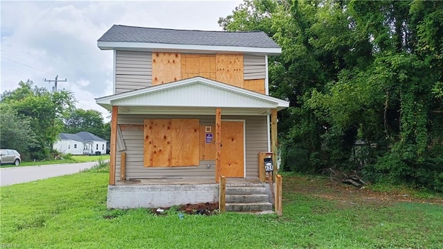 view of front of home with a front yard and covered porch