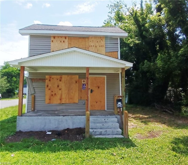 view of front of home with a porch and a front yard